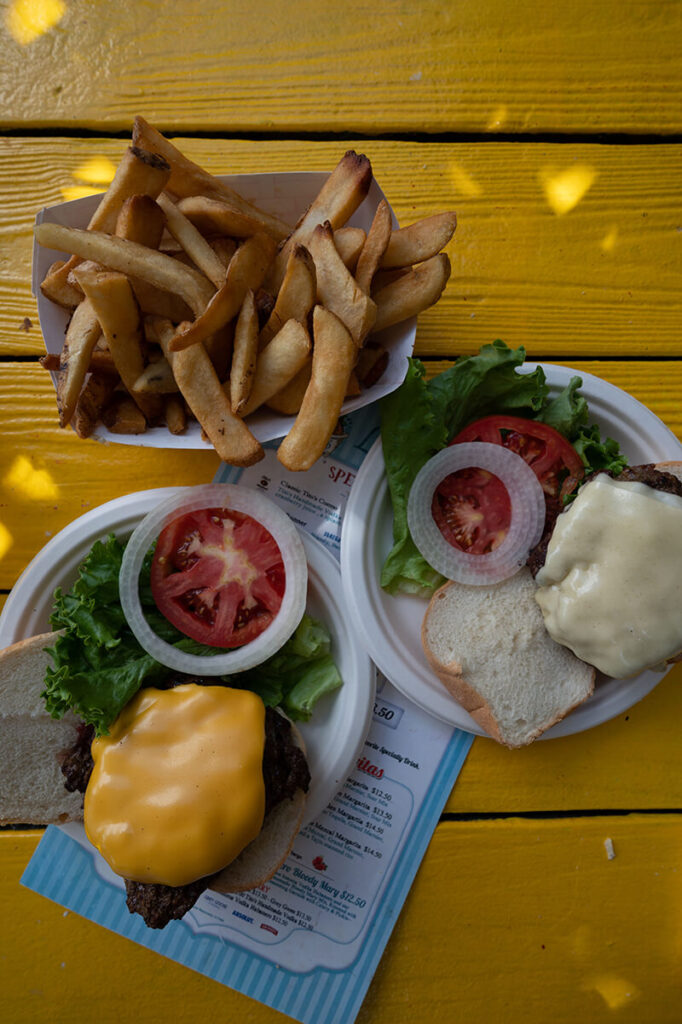 Two hamburgers and a boat of french fries on a table